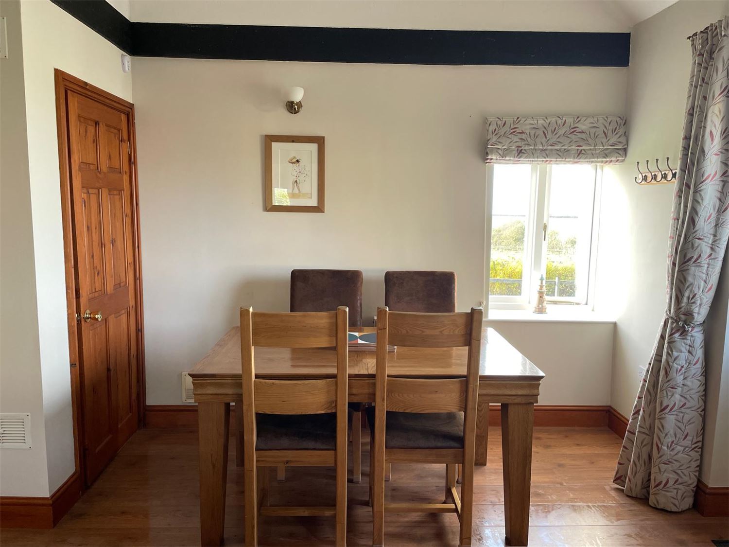 The view from the lounge looking towards the dining area where a table that seats up to 6 is situated. When seated at the table you have views over farmland and towards the sea.