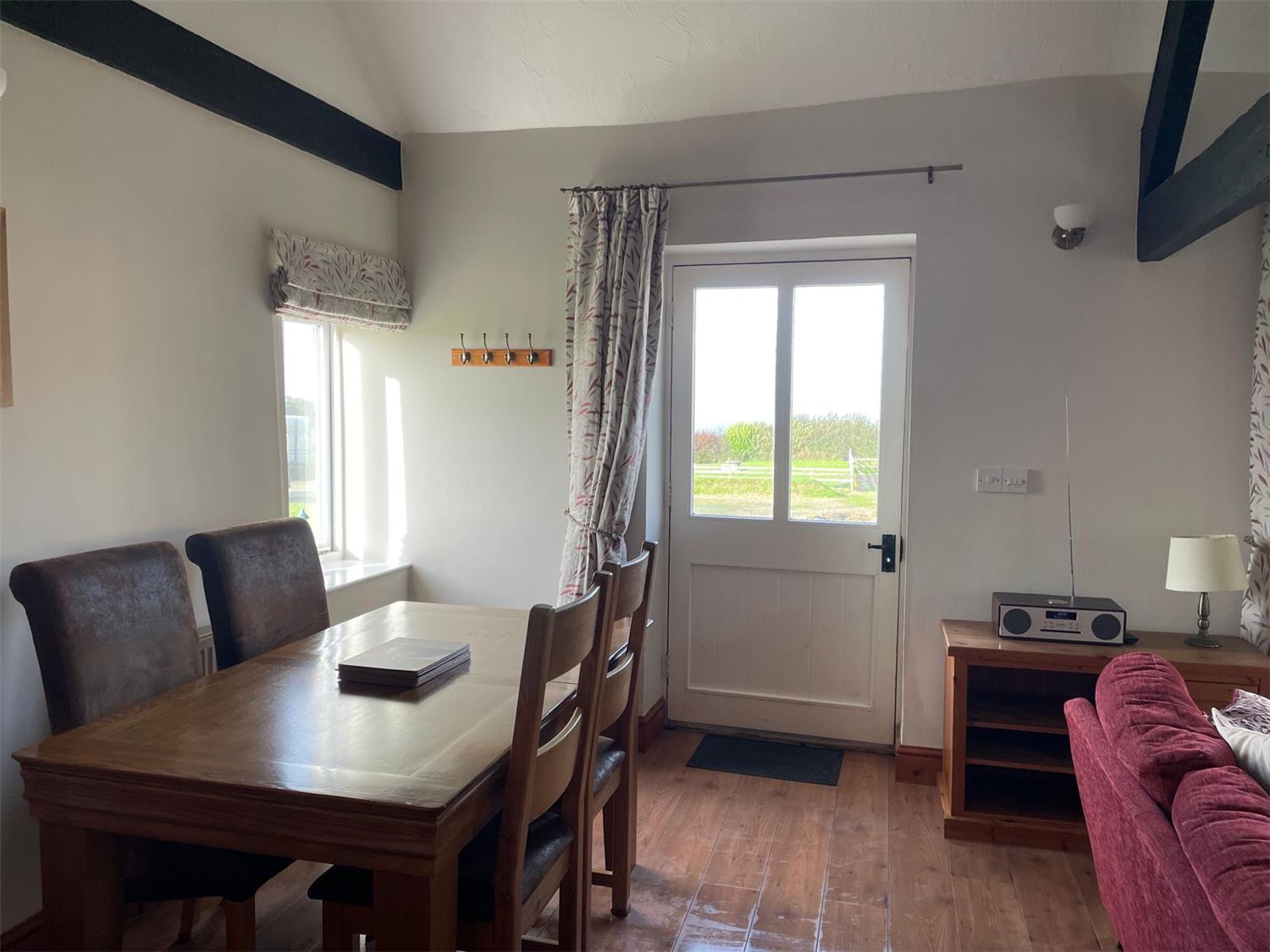 A photo from the entrance looking into the lounge with a double sofa and two single sofas, a gas fire. Onward views towards the kitchen