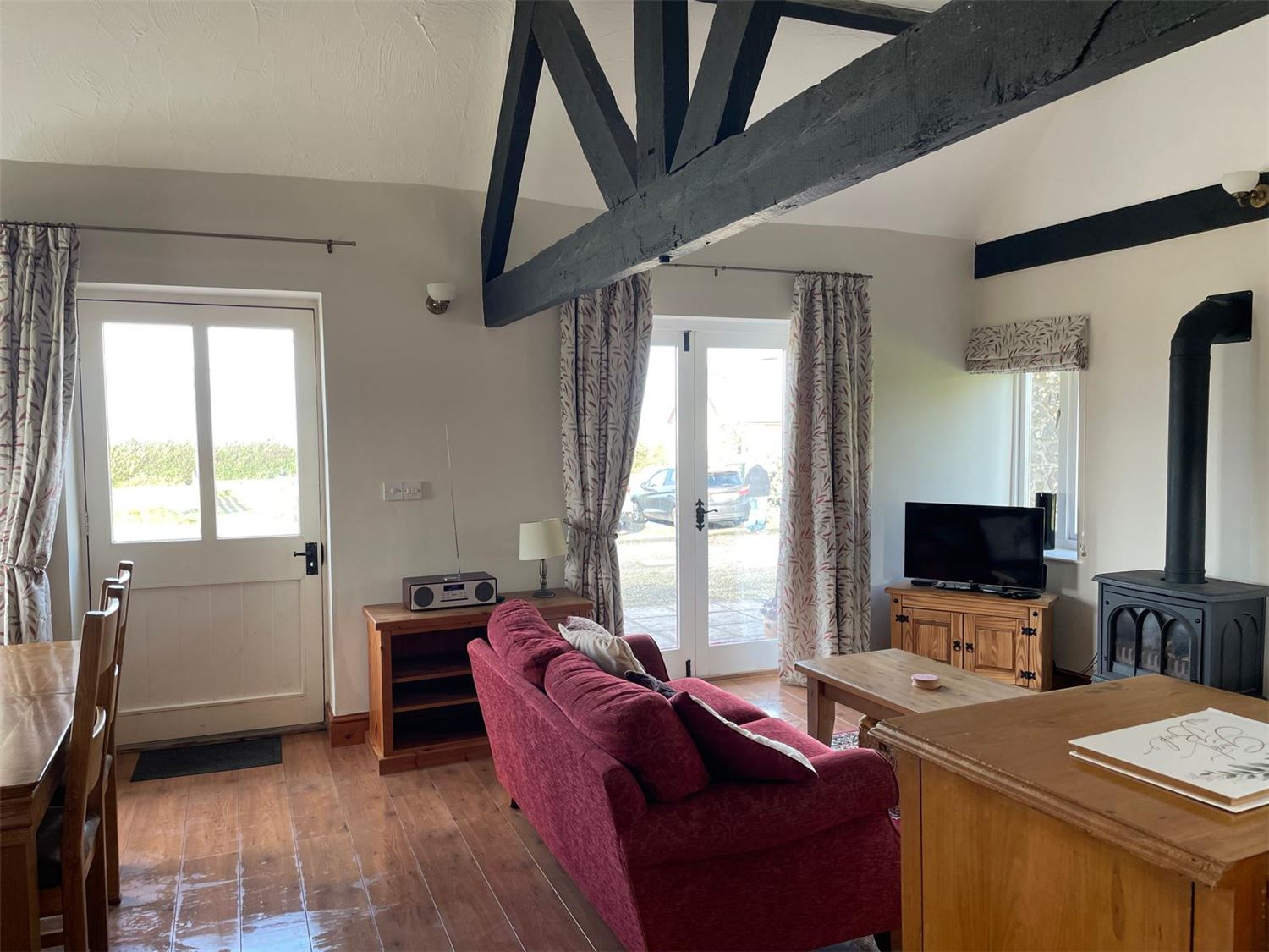 A photo from the entrance looking into the lounge with a double sofa and two single sofas, a gas fire.